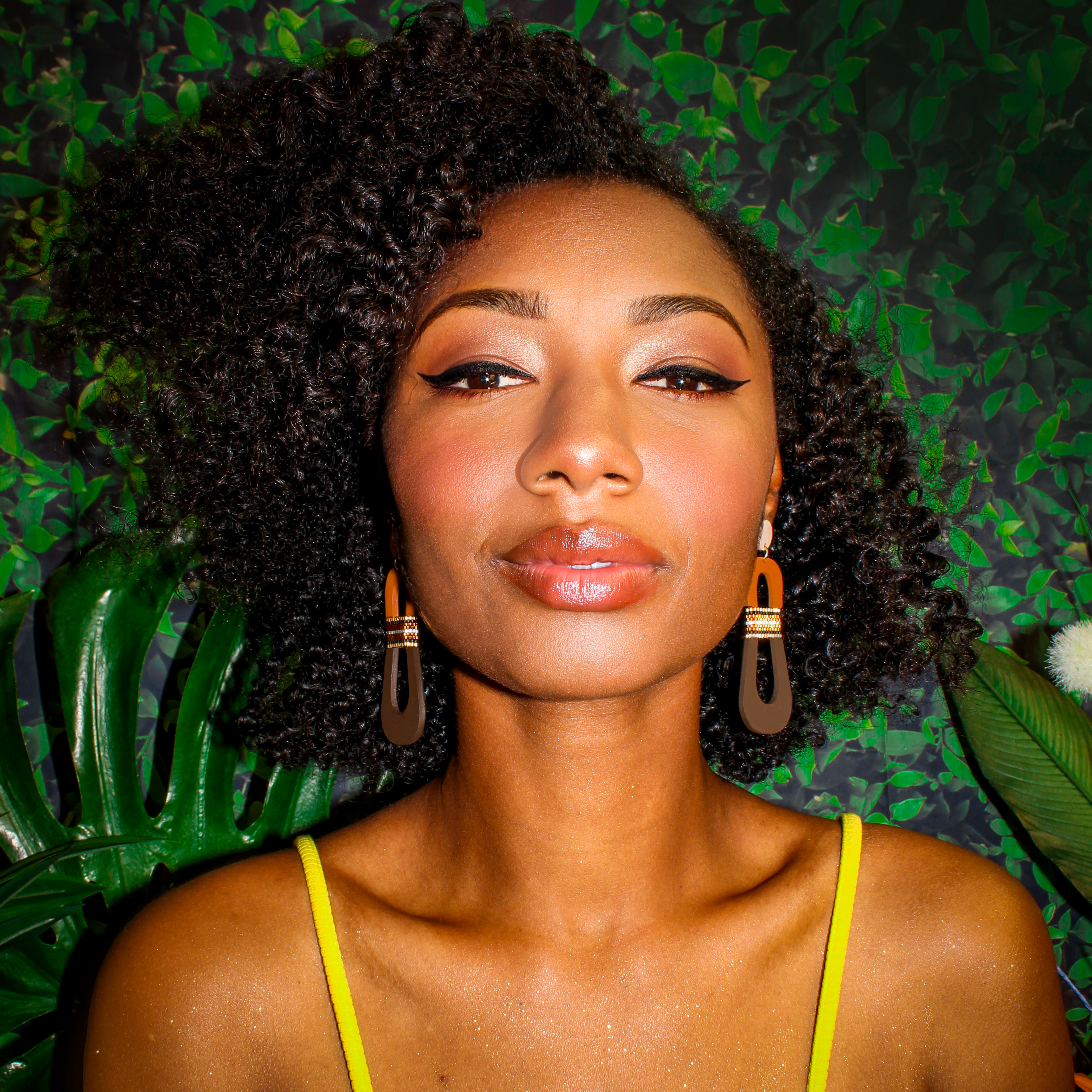 Model wearing modern, curvy, color blocked neutral tone statement earrings with hand-beaded accents by the brand SCOTCHBONNET.