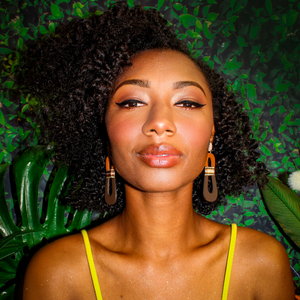Model wearing modern, curvy, color blocked neutral tone statement earrings with hand-beaded accents by the brand SCOTCHBONNET.