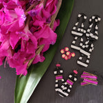 Hand crafted modern, curvy, black and white striped statement earrings with hand-beaded magenta accents by the brand SCOTCHBONNET.