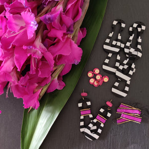 Hand crafted modern, curvy, black and white striped statement earrings with hand-beaded magenta accents by the brand SCOTCHBONNET.