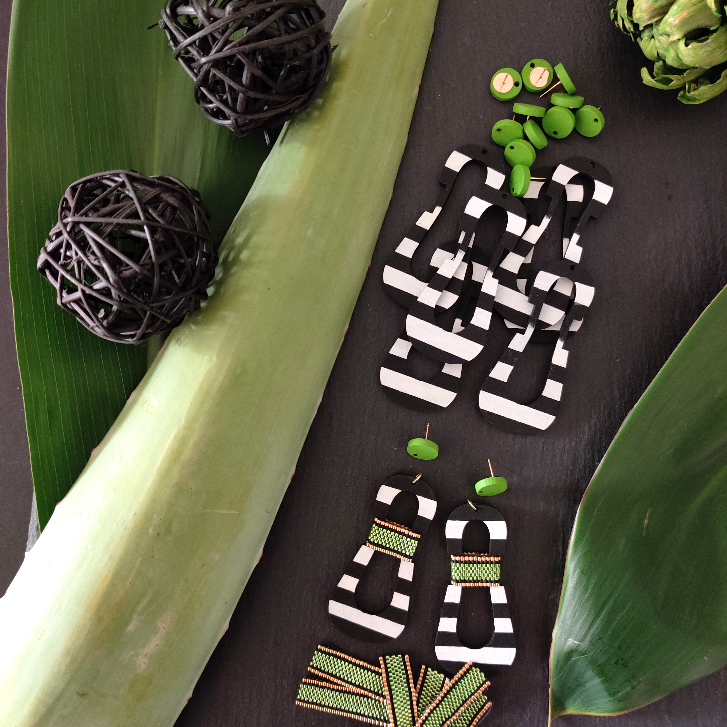 Handcrafted modern, curvy, black and white striped statement earrings with hand-beaded chartreuse accents by the brand SCOTCHBONNET.
