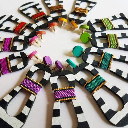 Modern, curvy, black and white striped statement earrings with hand-beaded colorful accents by the brand SCOTCHBONNET.