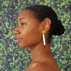 Model wearing geometric chartreuse, white, and black color blocked statement earrings by the brand SCOTCHBONNET.