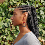Model wearing modern, curvy, red, brown, and dark brown color blocked statement earrings with hand-beaded accents by the brand SCOTCHBONNET.