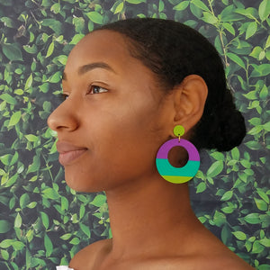 Model wearing large, round, chartreuse, teal and purple color blocked neutral tone statement earrings by the brand SCOTCHBONNET.