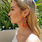 Side view of model wearing modern, curvy, yellow, magenta and orange color blocked statement earrings with hand-beaded accents by the brand SCOTCHBONNET.